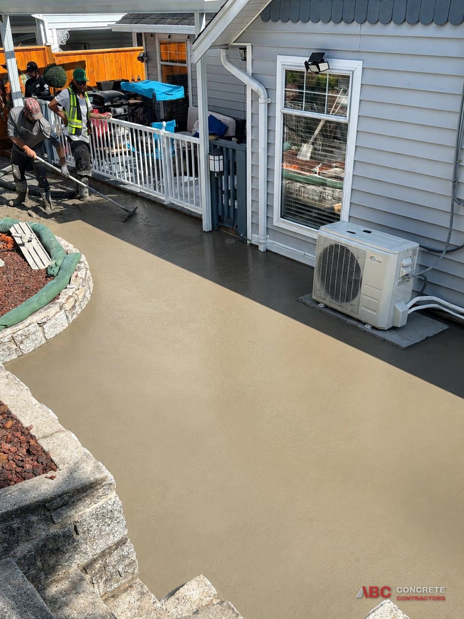Backyard patio finished with a sand-coloured decorative overlay and a dark charcoal border